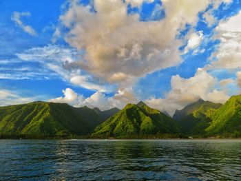 Scenic view of lake by mountains against sky