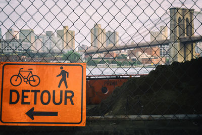 Close-up of warning sign on chainlink fence