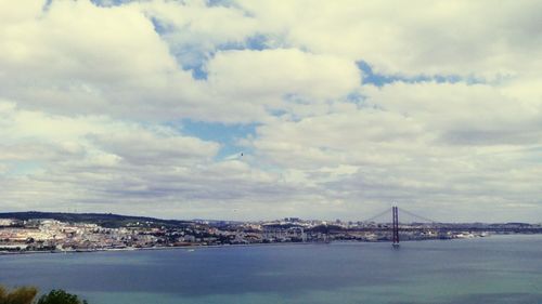 Scenic view of river by city against sky