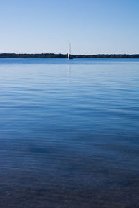 Sailboat in sea against clear sky