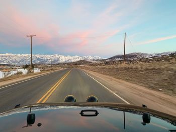 Road amidst snowcapped mountains against sky