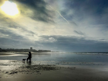 Silhouette man on beach against sky