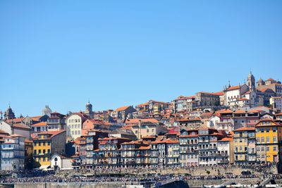 Houses in town against clear blue sky