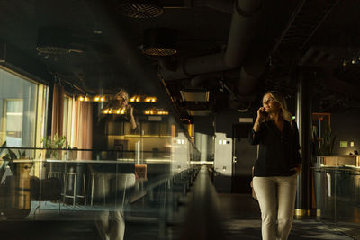 Woman using phone in cafe