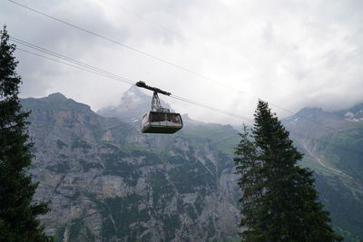 Low angle view of overhead cable car against sky