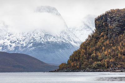 Idyllic view of snowcapped mountains by sea