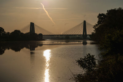 Bridge over river against sky during sunset