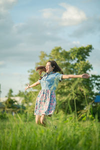 Woman wearing mask on field against sky