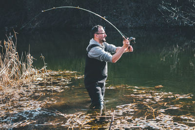 Man fishing in lake at forest