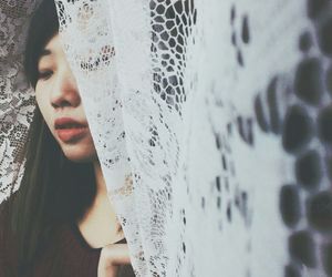 Portrait of young woman looking through window