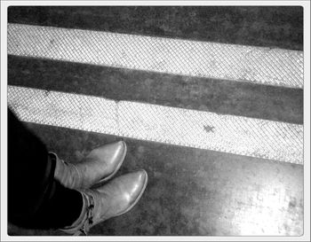 Low section of person standing on tiled floor