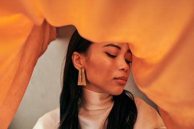 Close-up portrait of beautiful young asian woman with fabric props