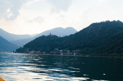 Scenic view of lake by mountains against sky