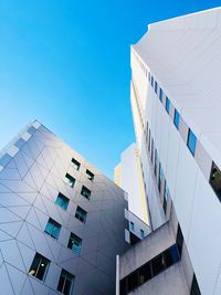 Low angle view of modern building against clear blue sky