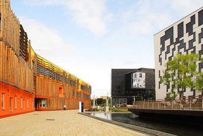 Canal amidst buildings in city against sky