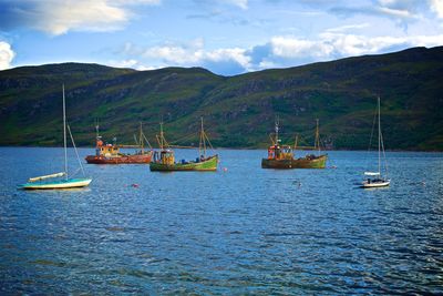 Boats sailing in sea against sky