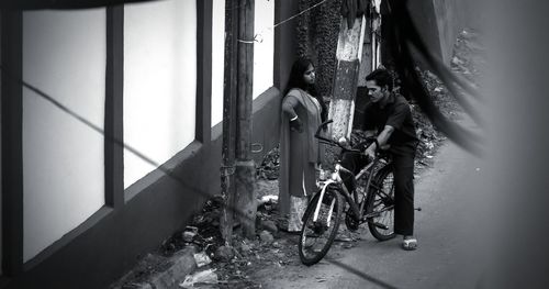 People on bicycle against building in city