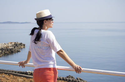 Young woman looking at sea against sky