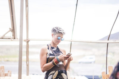 Mid adult woman using mobile phone outdoors