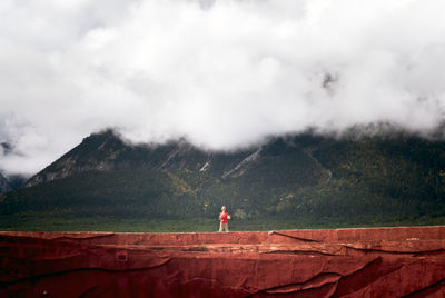 Man standing on mountain against sky