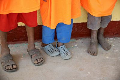 Low section of people with dirty legs standing on footpath