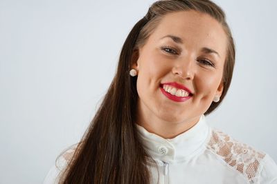 Close-up portrait of happy woman with dimples against white background