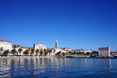 Buildings in city against clear blue sky