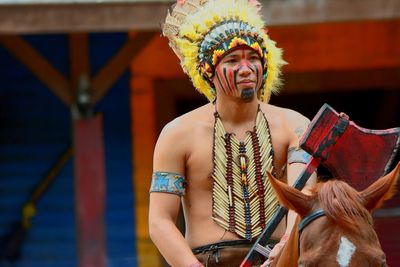 Man with face paint sitting on horse