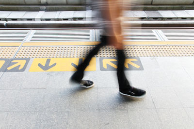 Blurred motion of man walking on railroad station platform