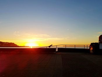 Scenic view of beach against sky at sunset