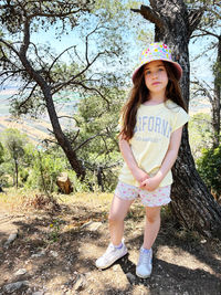 Portrait of young woman standing on field