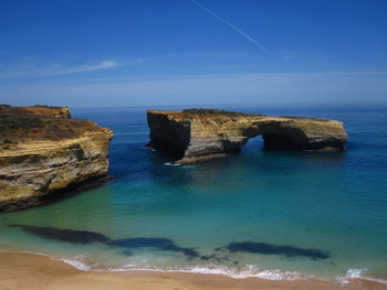 Scenic view of rocks in sea against blue sky