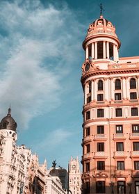 Low angle view of buildings against cloudy sky