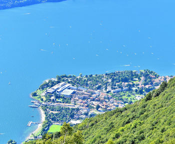 High angle view of buildings and sea against blue sky