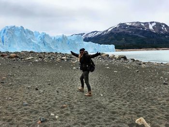 Full length of woman standing at beach during winter