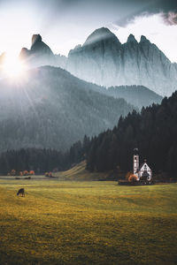 Scenic view of field and mountains against sky