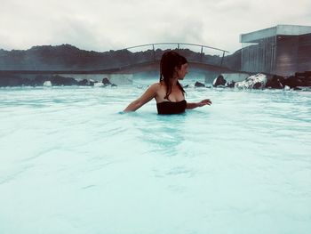 Woman in swimming pool against sky