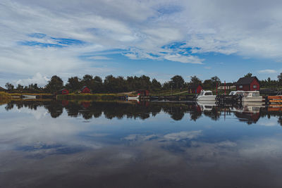 Scenic view of lake by trees against sky