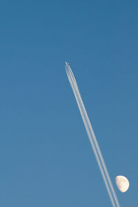 Low angle view of airplane flying against blue sky