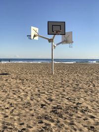 Basketball hut on beach against clear sky