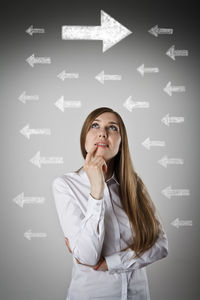 Young woman looking away against white background