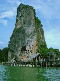 Built structure on rocks by sea against sky