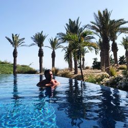 Man swimming in pool against clear sky