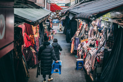 Rear view of people walking in street market