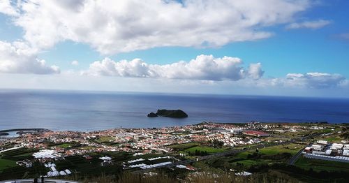 High angle view of town by sea against sky