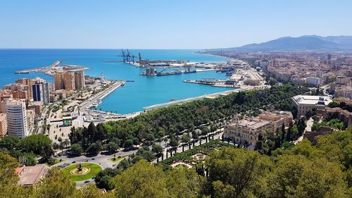 High angle view of townscape by sea against clear sky