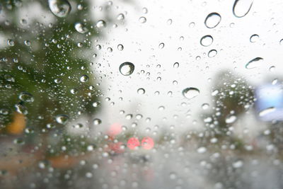 Close-up of wet glass window during rainy season