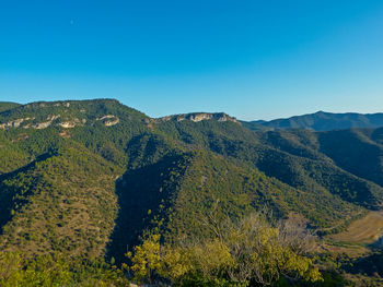 Scenic view of mountains against clear blue sky