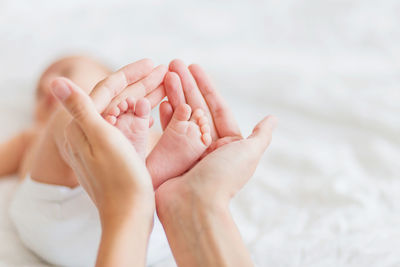 Cropped hands of mother holding baby feet