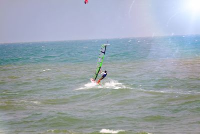 Man windsurfing on sea against clear sky